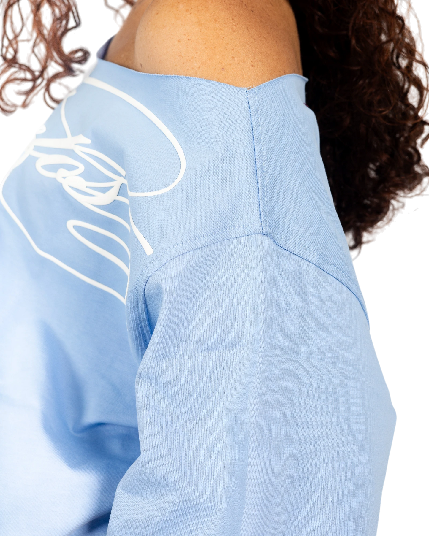 Anetos baby blue off-shoulder top with white graphic print on sleeve. Soft cotton blend.