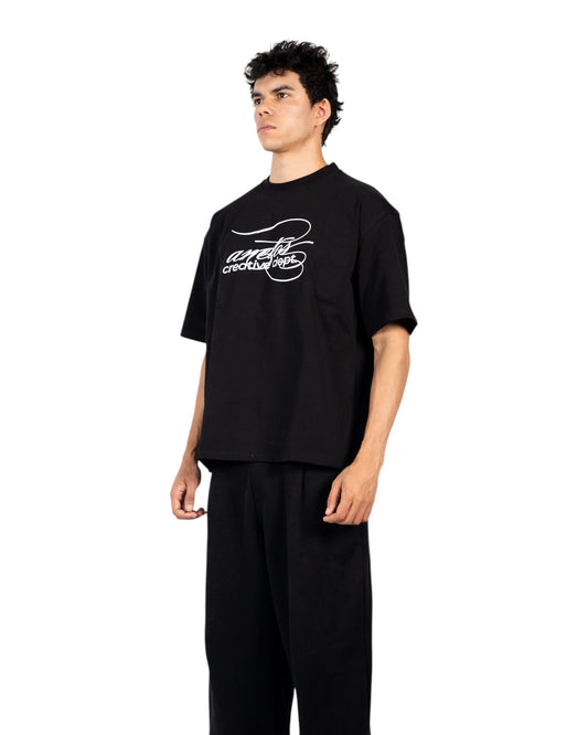 Anetos black cotton t-shirt with white 'creative dept.' graphic print on chest. Short sleeves, crew neck.