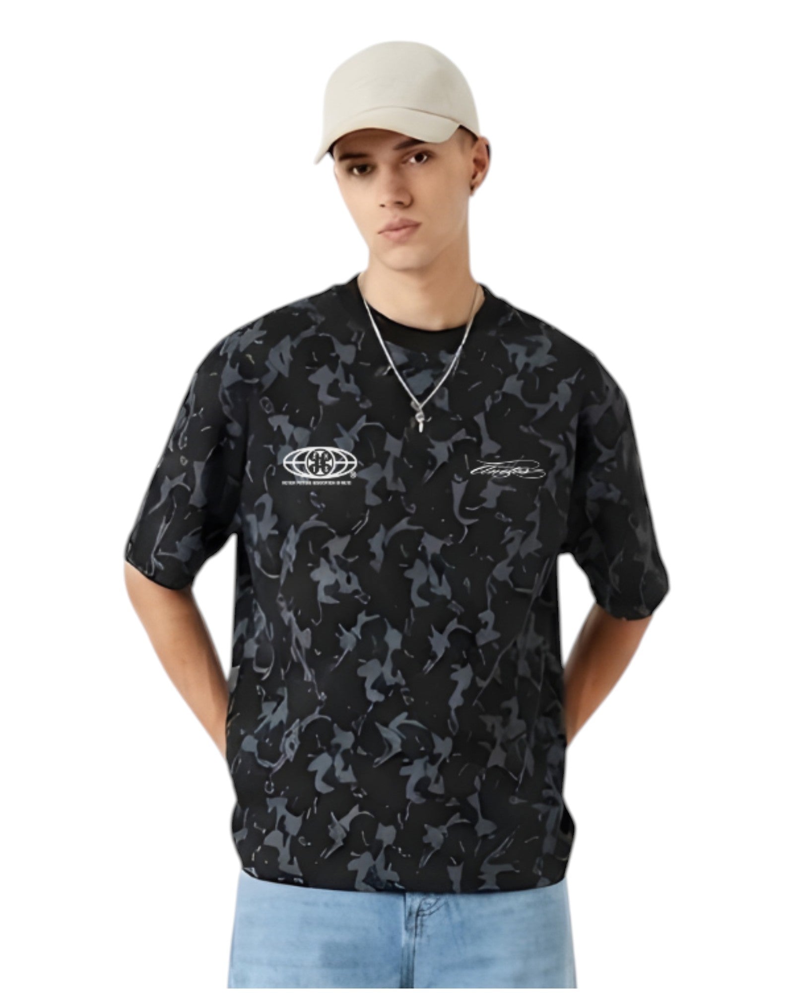 Anetos Blackout Camo Tee with a relaxed fit, featuring a black and grey camouflage pattern and short sleeves. Model wears light wash jeans and a beige cap.