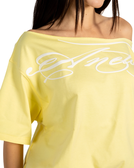 Anetos butter yellow off-shoulder top with white script logo detail. Short sleeves, soft fabric.