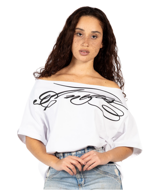 Anetos white off-shoulder top with black graphic print, paired with light wash wide-leg jeans.